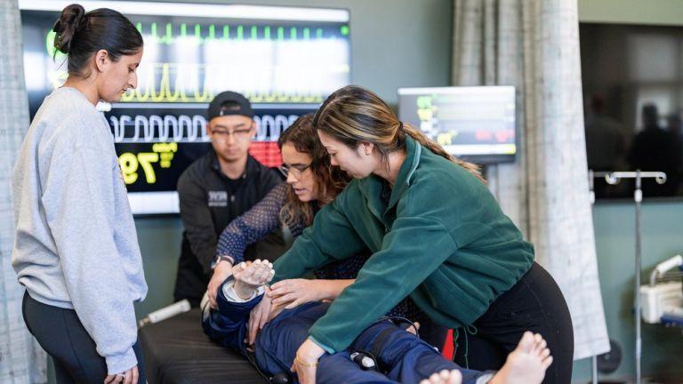 Students working with mannekin in clinical lab