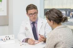 student showing hearing aids to patient in audiology clinic