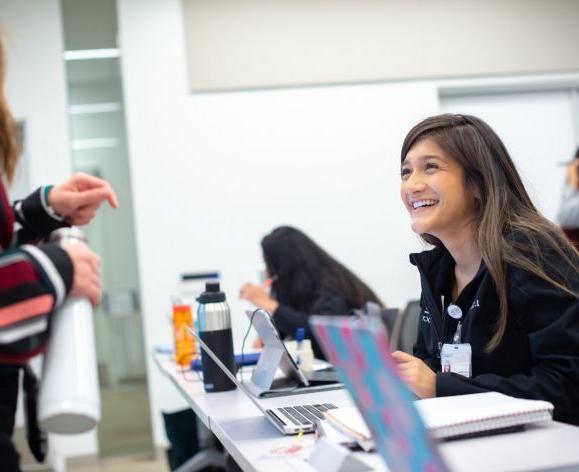 students smiling at desk